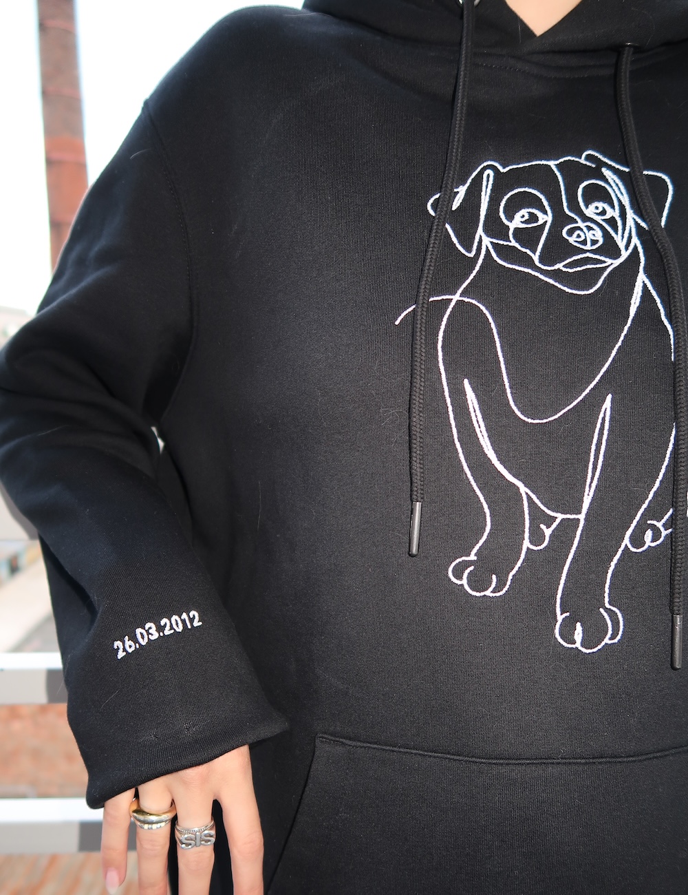Svart hoodie med personlig hundbroderi på ärmen