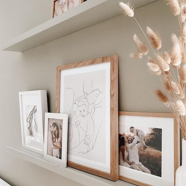 Fotovägg med familjebilder, inklusive en Line Art-teckning av en ung familj, Instagram-inlägg från @adriane