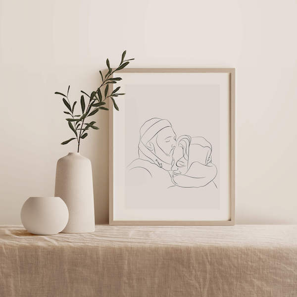 Line Art-teckning av ett par, placerad i en ram på ett bord bredvid en växt